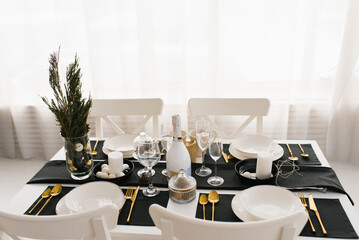 Family Christmas dinner at a set table. Living room interior in black and white