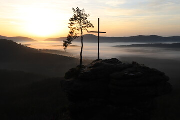 The Rötzenfelsen in the Palatinate Forest in Germany. Sunrise on a viewpoint in autumn, with fog in the valley and romantic colors in the sky