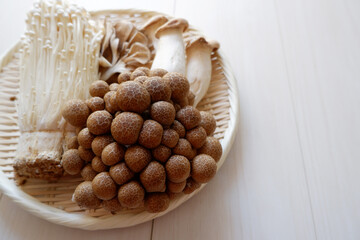 Flat lay composition with fresh mixed mushrooms on white wooden table, space for text.