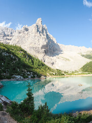 Stunning view of the Lake Sorapis (Lago di Sorapis) with its turquoise waters surrounded by a forest and beautiful rocky mountains, Dolomites, Italy.