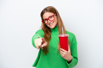 Young caucasian woman drinking soda isolated on white background pointing front with happy expression