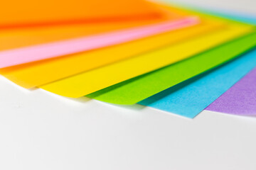 白い机の上に重ねられたカラフルな折り紙