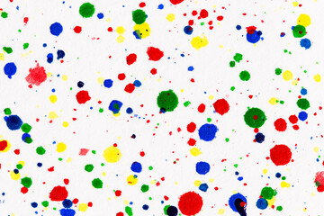 Paint splatters on bright material. Watercolor on white paper.