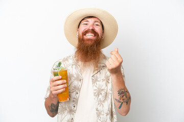 Redhead man with long beard drinking a cocktail on a beach isolated on white background making money gesture