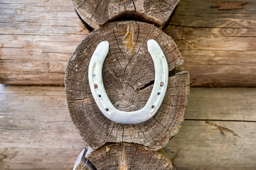 Metal horseshoe hanging on the wall of a wooden house