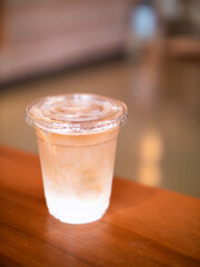 Soft focus iced-latte coffee on wooden table with blurred background