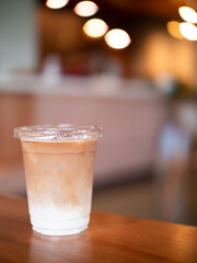 Soft focus iced-latte coffee on wooden table with blurred background