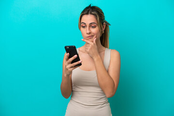 Young caucasian woman isolated on blue background thinking and sending a message