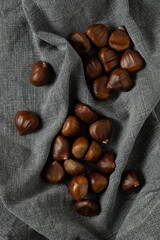 Fresh edible chestnuts. On gray tablecloth, top view.