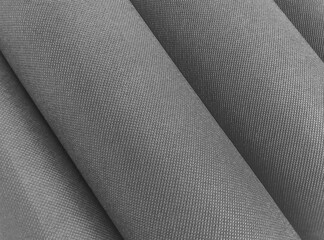 textured non-woven polypropylene fabric in gray with corrugated rolls. rough textile background