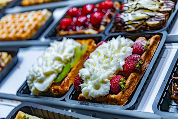 Belgian waffles with fruits put up for sale in shop in Brussels