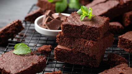 Chocolate brownies garnished with mint on cooling rack. Sweet food