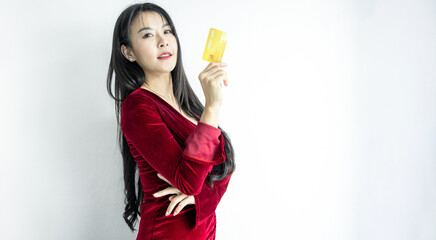 Beautiful Asian woman in red dress holding credit card on white background, Asian woman smiling showing presenting credit card, Woman holding bank business credit card, copy space.