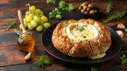 Baked Camembert cheese in sourdough bread with rosemary, garlic, thyme
