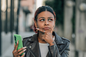 woman in the street with mobile phone and expression of doubt or mistrust