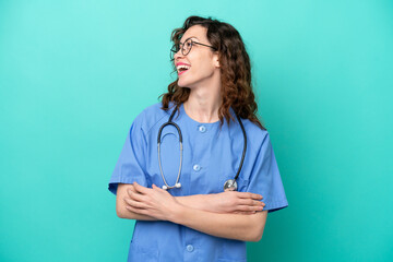 Young nurse caucasian woman isolated on blue background happy and smiling
