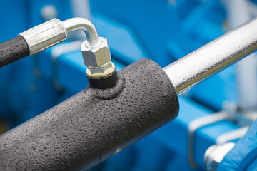 Obraz premium Black piston or actuator in blue pneumatic or hydraulic machine. Technology