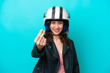 Young caucasian woman with a motorcycle helmet isolated on blue background making money gesture