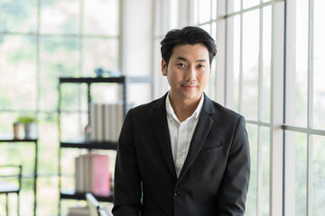 Asian, businessman and office. Portrait of Asian business man wear suit at the office. Smiling Asian business man standing with background modern office