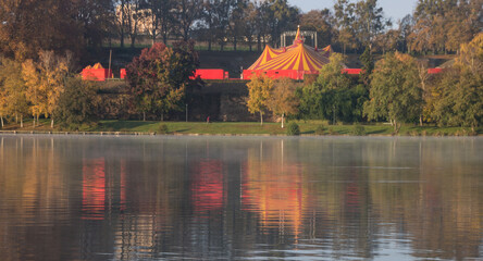 chapiteau de cirque se reflétant dans un lac