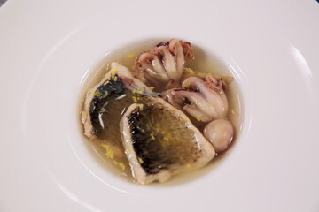 Fish soup with fish fillet on a white plate. Isolated. Top view