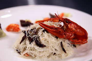 Spaghetti with crayfish on a white plate. Top view. Asian food style