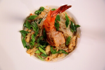 Seafood dish. Rice with king shrimp on a white plate. Side view. Asian food style