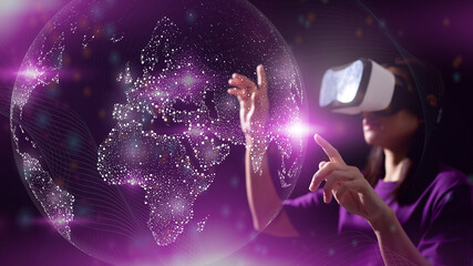 Close up of hand woman using glasses of virtual reality or VR on dark background. Learning is...