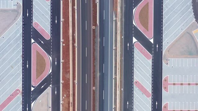 Parking lot or rest area (lay-by) on a large road, such as highway, motorway or expressway. Aerial drone top down view of almost empty space and pattern of colorful geometric dividing lines.
