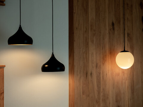 Twin ceiling lighting in the dark room. Two hanging lamp or round ceiling lamp decorated as a steps and round light full moon shape on white and wood wall.