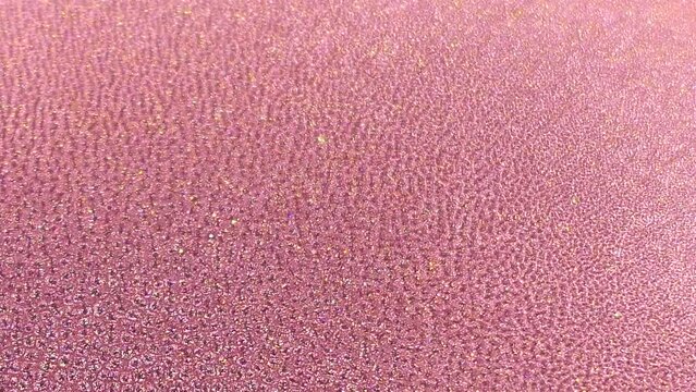 Rose colored glitter ink. Abstract texture background. Macrophotography.