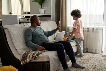 Father show stop gesture to son with constructor