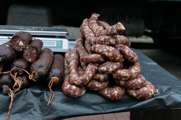 Blood sausage and cured homemade sausage on the counter of the village market. Natural food.