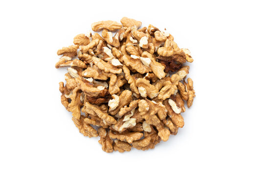 Closeup of big shelled walnuts pile on white background. Nuts are a source of vegetable protein.