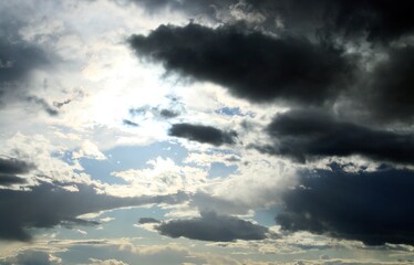 Fototapeta na wymiar El sol a través de un claro de nubes. Cielo tormentoso al atardecer con nubes oscureciendose.