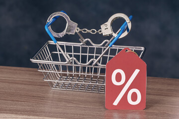 Percent sign with handcuffed shopping basket. Discounts addiction concept
