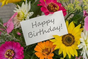 Birthday card with colorful summer flowers and the lettering Happy Birthday 