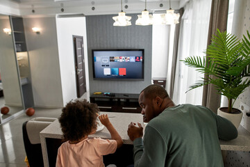 Dad and son look at each other during have lunch