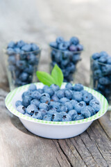blueberries in a glass bowl on a wooden background	