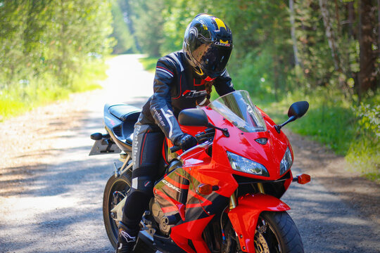 KRASNOYARSK, RUSSIA - June 23, 2018: Beautiful girl motorcyclist in full gear and helmet on a red and black Honda 2005 CBR 600 RR (PC37)