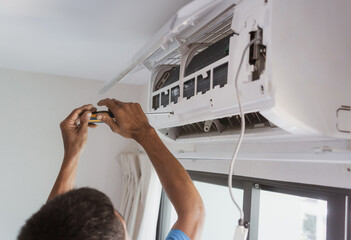 Technician electric cleaning home air conditioner indoors.