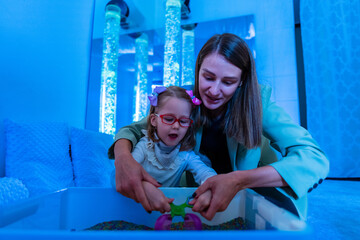 Child with physical disability in sensory stimulating room, snoezelen. Child living with cerebral...