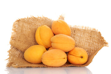 Several juicy pineapple apricots with a jute napkin, close-up, on a white background.