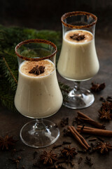 Traditional Christmas winter drink eggnog with cinnamon  in glasses