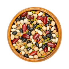 Mixed dried pulses in a wooden bowl, from above. Colorful mix of red kidney, black and white beans,...
