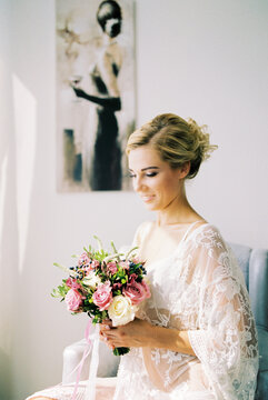 Bride with a bouquet of flowers sits in a chair