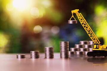 Construction cranes are stacking coins. business investment ideas