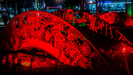 Chinese style red bridge glows at night in the park