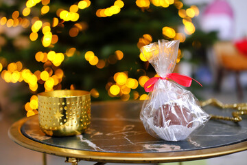 Chocolate bomb in the package on the table against the background of Christmas lights