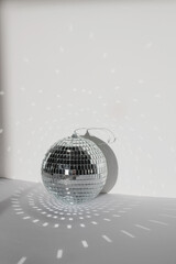 Disco ball on white wall background with reflection